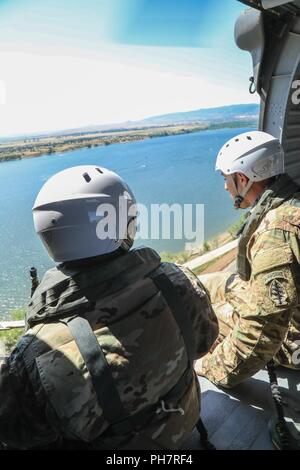 Us-Armee Soldaten, zugeordnet zu den 10 Special Forces Group (Airborne), Fliegen über Chatfield Behälter während ein Helo-cast Schulungsveranstaltung in der Nähe von Littleton, Colorado, 29.06.2018. Eines der Ziele im Rahmen der Schulung erreicht war ihre Fähigkeit, aus der Luft anzugreifen sowie das Meer zu festigen. Stockfoto