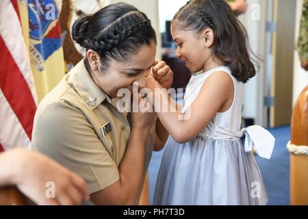 GARDEN CITY, New York (28. Juni 2018) Engineman 1. Klasse Angela Rojas' Tochter pinning auf Ihrem neuen E6 Crow während einer frocking Zeremonie auf dem Achterdeck von Marine-einziehende Bezirk New York statt. Rojas, ein Eingeborener von Mercedes, Texas und Absolvent von Mercedes High School, wurde zur First class Petty Officer durch ihre Punktzahl auf der März Marine erweitert - breite Förderung Prüfung. Stockfoto