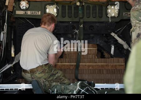 Staff Sgt. Jakob Fogle, 136 Airlift Wing Lademeister, prüft ein High Mobility Multipurpose Radfahrzeug, oder Humvee auf eine Palette Mittwoch, Juni 27, 2018, von der Naval Air Station Fort Worth gemeinsame Reserve Base, Texas gesichert. Die Texas militärische Abteilung unterstützt diese Gemeinsame Fortbildungsinitiative mit 294 die Texas National Guard Quartermaster Unternehmen, Camp Mabry in Austin und den 136 AW, mit den ersten vollen Erfolg Texas Humvee airdrop aus einer C-130 Hercules. Stockfoto