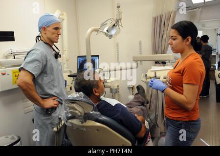 Kapitän Matthew Ticich, eine allgemeine Zahnarzt zu 10 Special Forces Gruppe zugewiesen wurde, und Andrea Betancourt, einen Freiwilligen aus Socorro High School Gesundheitsberufe Akademie, helfen dem Patienten im Rahmen eines zahnmedizinischen Siebung an Escontrias Early Childhood Centre in Fredericksburg, Texas. Ticich ist einer von rund 50 US-Armee Finden und US-Armee Soldaten, die in Partnerschaft mit der Texas A&M Colonias Programm medizinische Versorgung in unterversorgten colonias Bevölkerung El Paso County zur Verfügung zu stellen. Dienstleistungen, die von militärischen Personal zur Verfügung gestellt werden durch die Abteilung der innovativen Verteidigung Readiness Training fertig Stockfoto