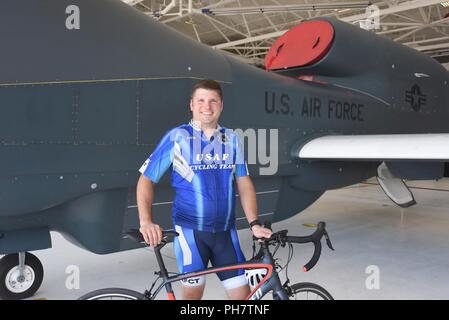 Staff Sgt. Douglas Pierre, 319 Bauingenieur Squadron Feuer Kapitän, steht vor einem RQ-4 Global Hawk Juni 25, 2018 in Grand Forks, North Dakota. Pierre ist ein Mitglied der US Air Force Cycling Team und derzeit das einzige Mitglied im Grand Forks AFB stationiert. Stockfoto