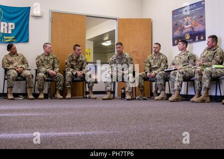 Command Sgt. Maj. Stephen Helton, 7 Infanterie Division Command Sergeant Major, besuche die 16. Combat Aviation Brigade Raptor Ausfallsicherheit Center, an Joint Base Lewis-McChord, Washington, 26. Juni 2018. Staff Sgt. Vanessa Alvarado, 16 CAB religiöse Angelegenheiten NCO, gab Helton eine Tour der Raptor Ausfallsicherheit Center und teilte ihm die Leistungen in der Einrichtung zur Verfügung gestellt. Sie erhielt auch eine Exzellenz Münze aus Helton. Danach Helton sprach mit dem Senior Non-Commissioned Officers in Führungspositionen innerhalb der Feuerwehr für ihre berufliche Entwicklung. Stockfoto