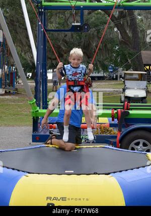 Brody Lindskog, Sohn von US Air Force Tech. Sgt. Levi Lindskog, 4.Platz starten Geschwader missile und Wartung, der Vandenberg Air Force Base, Kalifornien, springt auf einem Trampolin während der Freiheit Fest im Marina Park am Keesler Air Force Base, Ohio, 30. Juni 2018. Die Veranstaltung umfasste Karneval Fahrten, ein Burger Koch - weg, heiße Flügel und Wassermelone essen Wettbewerbe und ein Feuerwerk. Stockfoto