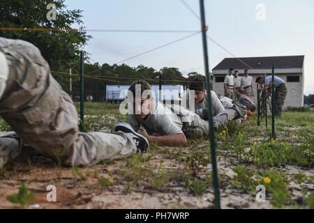 Junior ROTC Kadetten Armee Kriechen unter ein Hindernis bei einem Monster Mash bei Hurlburt Field, Florida, 29. Juni 2018. Ein Monster Mash ist ein Wettbewerb für die Herausforderung und team-Fähigkeiten zu stärken. Die 1 Special Operations Wing hosted Sommer Führung Schule für Junior ROTC Kadetten aus fünf lokale High School in einer Vielzahl von Führung und Teambildung Übungen unter der Anleitung von Air Commandos zu engagieren. Stockfoto