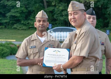 Chief Petty Officer Kevin Ramdass erhält ein Navy und Marine Corps. Commendation Medal von NHCPR des kommandierenden Offizier, Kapitän James C. Junge. Stockfoto