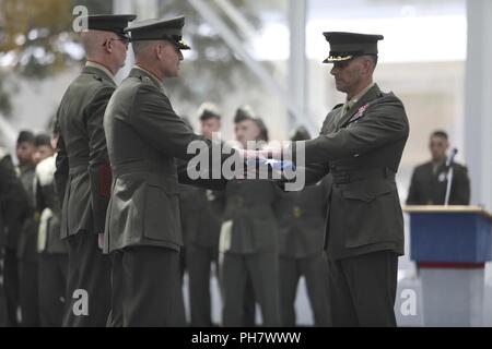 Us Marine Brig. Gen. Bradford J. Gering, Assistent des stellvertretenden Kommandanten für die Luftfahrt, präsentiert eine US-Flagge zu Oberst David C. Forrest, ausgehende kommandierender Offizier der Marine Aviation Training Support Group-21 (MATSG-21) während der MATSG-21 Ändern des Befehls Zeremonie am Naval Air Station Pensacola, Fla., 28. Juni 2018. Die Änderung des Befehls Zeremonie vertritt die offizielle Übergabe der Autorität des scheidenden Kommandeur, Oberst Forrest, der mit der eingehenden Kommandeur, Oberst Michael H. Johnson. Stockfoto