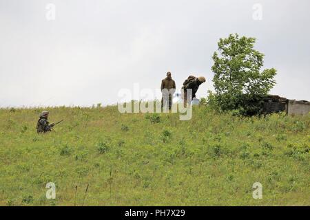 Service für Mitglieder mit einem ausländischen militärischen Beseitigung von Explosivstoffen (EOD) Team einen Hang Juni 26, 2018, am Badger Drop Zone im Süden Post als Teil der Ausbildung, die in der Übung kühnen Krieger 2018 am Fort McCoy, Wis fast 60 Flieger von National Guard Einheiten in 10 Staaten sowie Teams von internationalen Service Mitglieder Wer sind Teil der Beseitigung von Explosivstoffen Teams am Fort McCoy für 12 Tage im späten Juni geschult bis Anfang Juli als Teil der Übung. Training auch statt bei Volk Feld, Wis während des Trainings, das EOD-Personal abgeschlossen Szenarien im Konvoi, besiedelten Stockfoto