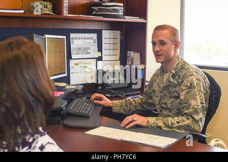 Us-Luftwaffe Kapitän Tyler Smith, 355 Fighter Wing Rechtsabteilung Personal Judge Advocate Assistant unterstützt eine militärische Ehegatte während einer unterzeichnen Veranstaltung in Davis-Monthan Air Force Base, Ariz., 27. Juni 2018. Dieses Ereignis geschieht monatlich und ist ein kostenloser Dienst, Pensionäre in die Tucson Gemeinschaft. Stockfoto