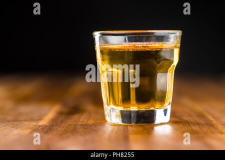 Glas alkoholische Getränk auf Holztisch. Whiskey in Glas. Stockfoto