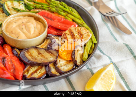 Gegrilltes Gemüse auf einem Teller mit Sauce, selektiven Fokus. Stockfoto