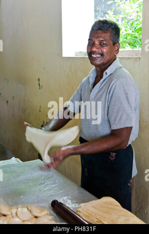 Vertikale Porträt eines Mannes, die traditionelle ungesäuertes Brot in Sri Lanka. Stockfoto