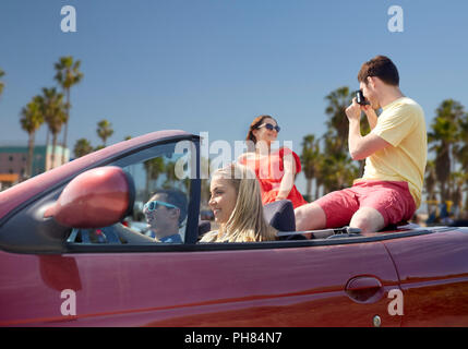 Freunde mit Kamera Fahrt im Cabrio Stockfoto