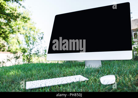 Selektiver Fokus der Computer mit leeren Bildschirm auf Gras im Freien Stockfoto