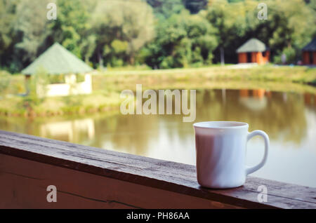 Porzellan weiße Tasse auf der Veranda mit Blick auf den See. Reisen Foto Stockfoto