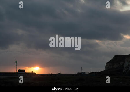 Sonnenuntergang und grauen Wolken bei Newhaven Hafen in East Sussex Stockfoto