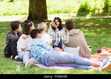 Freunde fotografieren im Sommer Picknick im Park Stockfoto