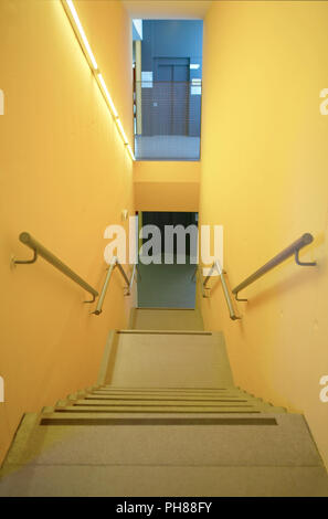 Gelbe Wände innen mit Treppen und Geländer. Niemand. Vertikale Stockfoto