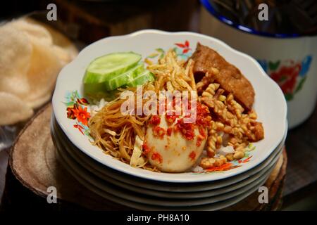 Nasi Uduk Betawi, der beliebten Reisgericht aus Jakarta. Herzhafte Kokosmilch Reis garniert mit verschiedenen Beilagen. Stockfoto