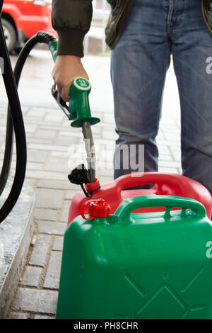 Mann in Jeans Gas Station in einer Kunststoff Benzin Stockfoto