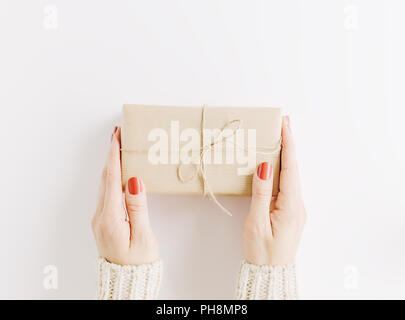 Frau mit Geschenk im Handwerk auf weißem Papier. Blick von oben. Flach Stockfoto