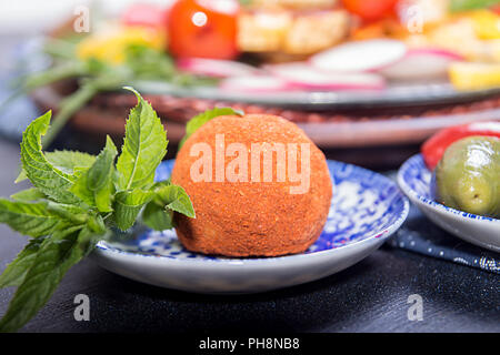 Käse belper Knolle, die in den Gewürzen roter und schwarzer Pfeffer, dekoriert mit Minze. Stockfoto