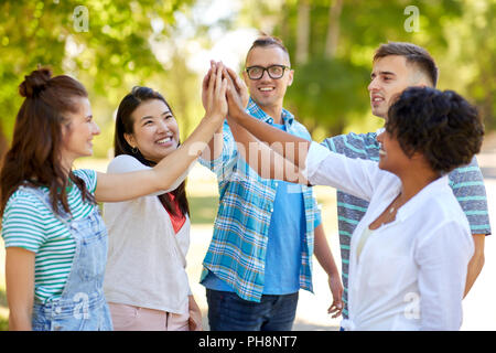 Gerne Freunde High Five in Park Stockfoto