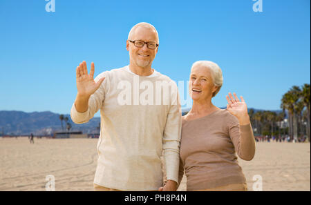 Gerne älteres Paar winkende Hände über Venice Beach Stockfoto