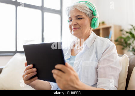 Ältere Frau in Kopfhörer Musik hören Stockfoto