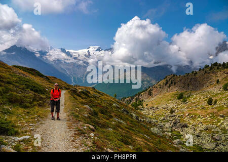 Einzelnen weiblichen Wanderer in Rot, auf Trail, Sommer im Nationalpark Hohe Saas, Hohsaa, Kabel-Auto oberhalb Saas Grund, Schweiz, Schweizer Alpen, Stockfoto