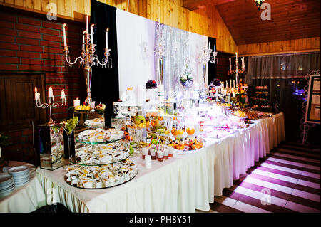 Hochzeitstafel Rezeption Eleganz mit Essen und Einrichtung. Brennende Kerze Stockfoto