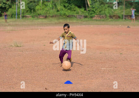 Mumbai, Indien - 8. Juli 2018 - indische Kinder spielen Fußball auf staubigen Fußballfeld Stockfoto