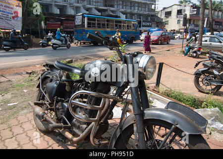 Goa, Indien - 8. Juli 2018 - Enfield Motorrad in typische Verkehrssituation auf indischen Straße in Canacona - Goa Stockfoto