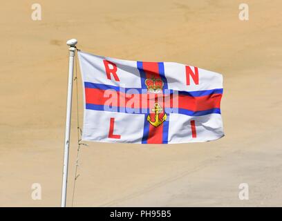 Royal National Lifeboat Institution Flagge, RNLI ensign Flagge gegen einen Sandstrand Boden zurück Stockfoto