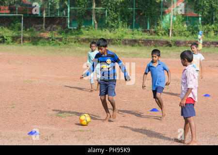 Mumbai, Indien - 8. Juli 2018 - indische Kinder spielen Fußball auf staubigen Fußballfeld Stockfoto