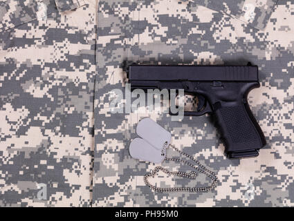 Camouflage battle Dress Uniform mit ID-Tags und Pistole Stockfoto