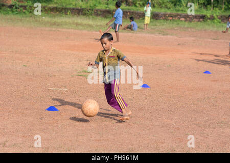 Mumbai, Indien - 8. Juli 2018 - indische Kinder spielen Fußball auf staubigen Fußballfeld Stockfoto