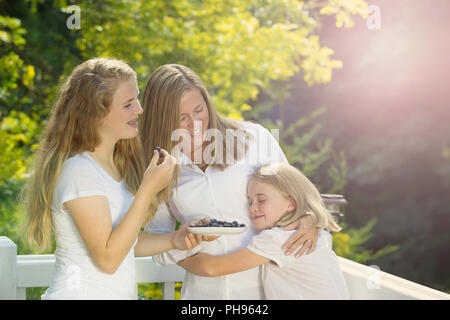 Familie genießen den Moment draußen an Deck während der Sommerzeit Stockfoto