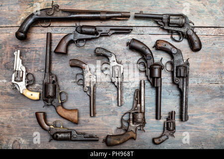 Armory Anzeige der historischen Gewehren und Pistolen in einer Ansicht von oben auf einem alten Holztisch Hintergrund Stockfoto