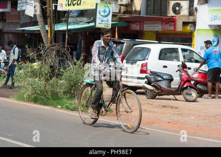 Goa, Indien - 8. Juli 2018 - Radfahrer in typische Verkehrssituation auf indischen Straße in Canacona - Goa Stockfoto