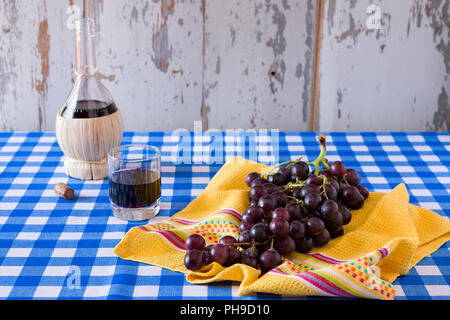 Strauß roter Trauben und einem Glas Rotwein Stockfoto