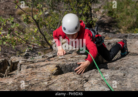 Ein Junge auf einem Multi pitch Klettern im Tal der Rhone, Schweiz Stockfoto