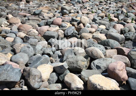 Wasser Steine Felsen Muster. Kiesel in der Nähe von Wasser. Runde Steine Hintergrund. Natur Hintergrund. Flußbett und Ufer. Stockfoto