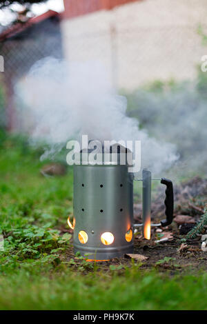 Feuern Sie Holzkohle vor dem Grill mit Kohle Chimney Starter Stockfoto
