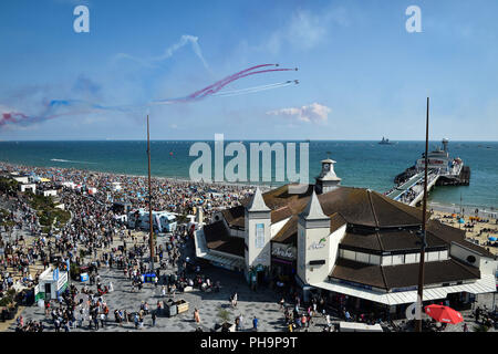 Die roten Pfeile zeigen die Mannschaft über den Pier als Tausende strömen zum Strand von Bournemouth während der jährlichen Luft Tag durchführen, da die Temperaturen beginnen über Teile von Großbritannien in der Zeit für das Wochenende zu klettern. Stockfoto