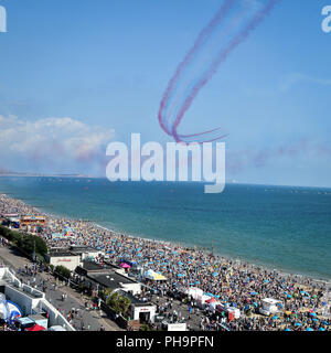 Die roten Pfeile zeigen die Mannschaft als Tausende strömen zum Strand von Bournemouth während der jährlichen Luft Tag durchführen, da die Temperaturen beginnen über Teile von Großbritannien in der Zeit für das Wochenende zu klettern. Stockfoto