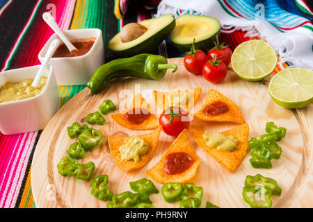 Nachos Chips und Gemüse auf einem Schneidebrett Stockfoto