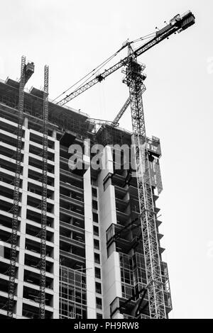 Bau von hoher Gebäude, das im Entwicklungsprozess und ein Kran Turm auf seiner Seite. Stockfoto