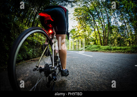 Weibliche Radfahrer Radfahren entlang einer Landstraße im Bowland, Lancashire, UK. Stockfoto