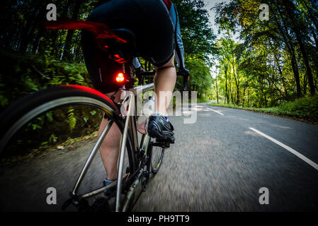 Weibliche Radfahrer Radfahren entlang einer Landstraße im Bowland, Lancashire, UK. Stockfoto