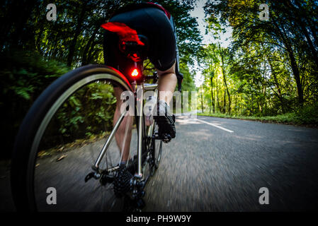 Weibliche Radfahrer Radfahren entlang einer Landstraße im Bowland, Lancashire, UK. Stockfoto